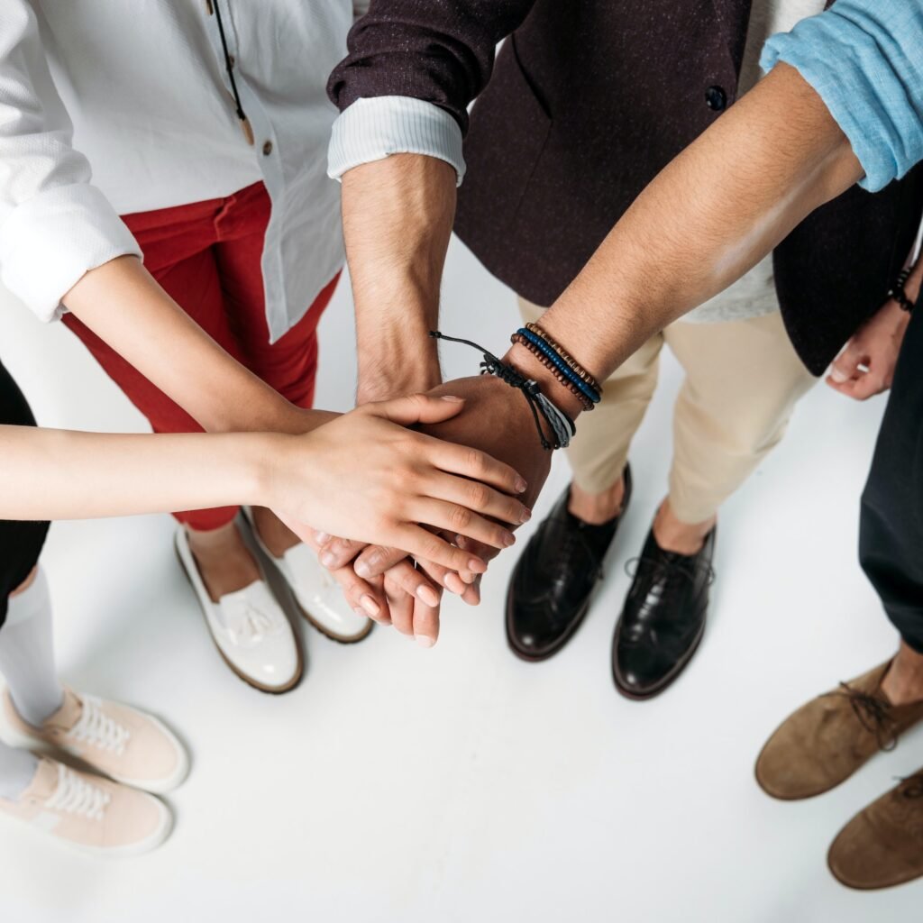 partial view of friends stacking hands together